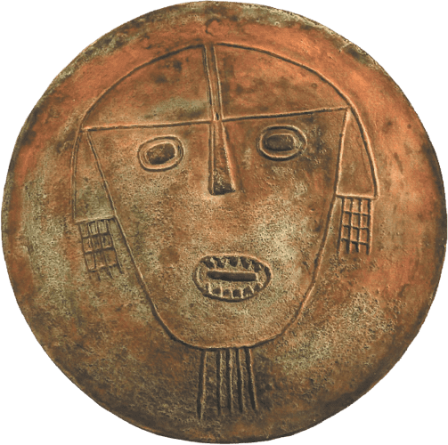 Disco de bronce con cabeza cortada en relieve, réplica de arte precolombino del noroeste argentino